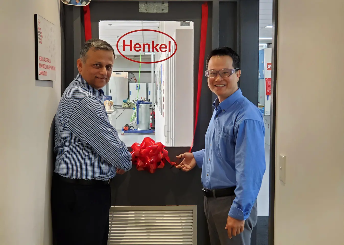 Aamir Qureshi (left), Operations & Supply Chain Manager, and Stephen Liu (right), Senior Chemist, cutting the ribbon to mark the official opening of the upgraded Innovation and Application Lab of Henkel Adhesive Technologies in Sydney.