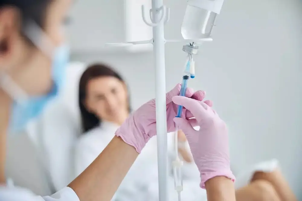 Zdravstveni delavec drži infuzijsko vrečko v zdravstvenem okolju.