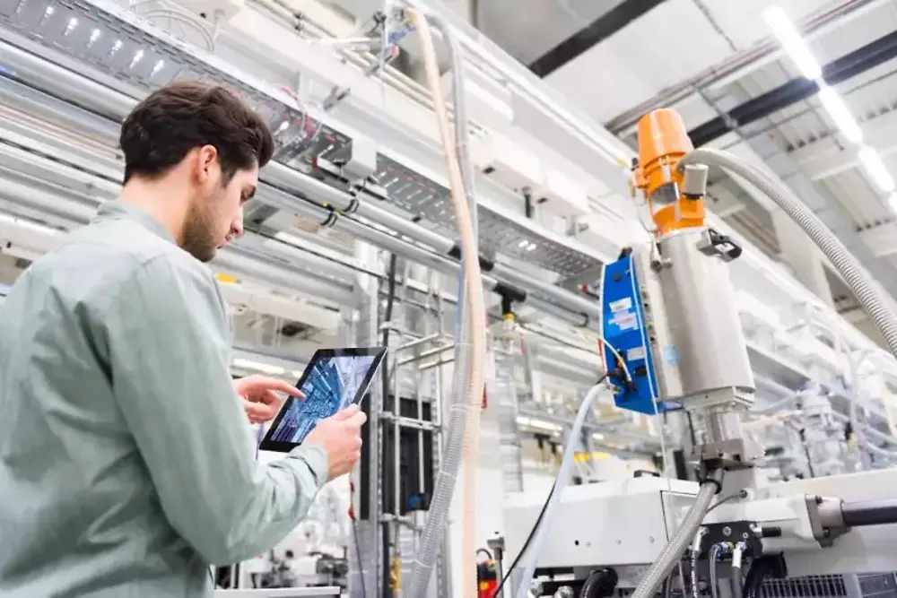 Delavci upravljajo stroje v industrijskem proizvodnem obratu.