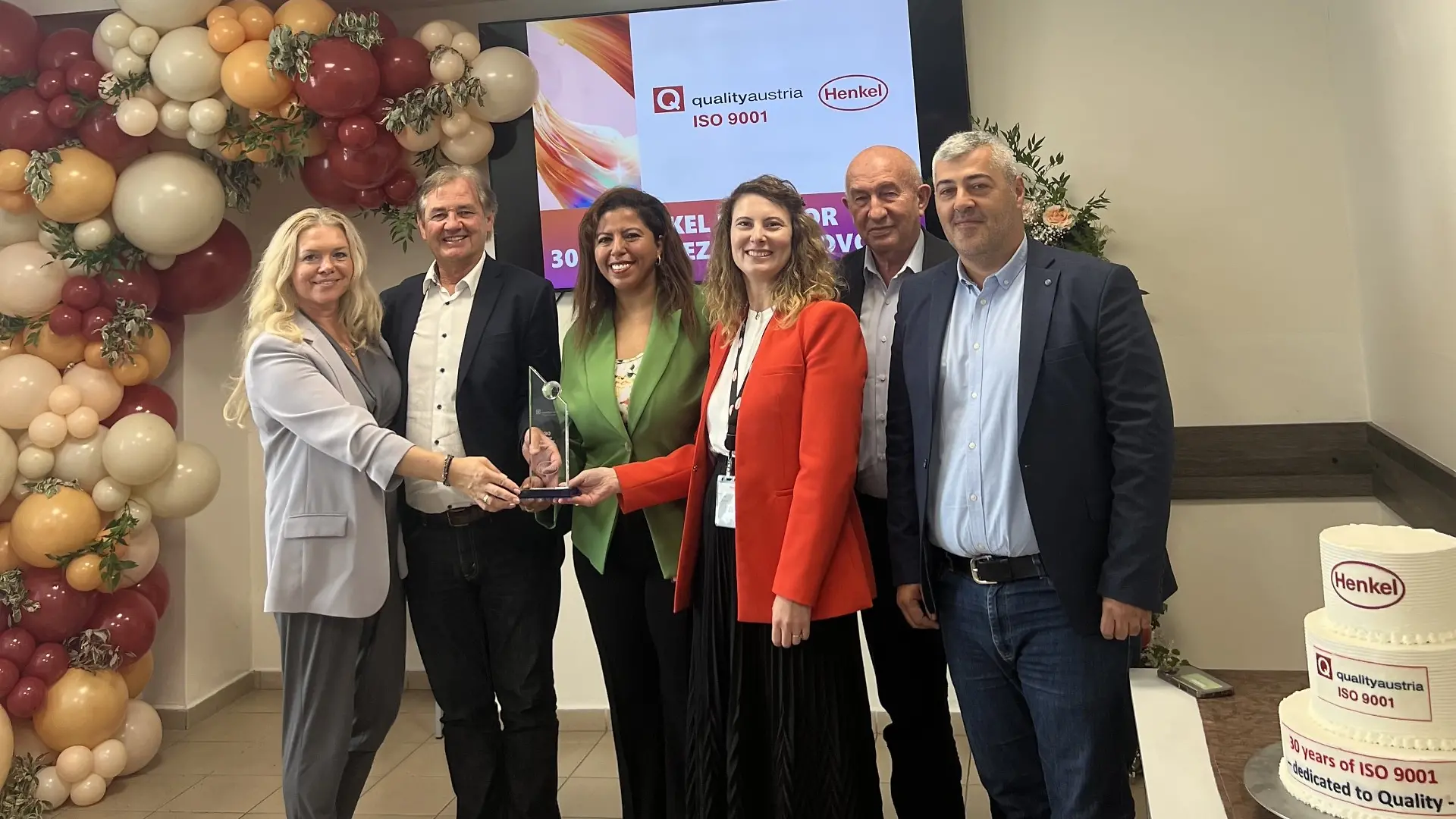 Podelitev certifikata ISO 9001, na fotografiji dr. Tatjana Lösch (revizorka Quality Austria), Manfred Haselbacher (glavni revizor Quality Austria), Amal Benfarhone (direktorica tovarne Henkel Maribor), Tamara Roj (vodja SHEQ Maribor), Vele Temelkoski (revizor Quality Austria), Aleksandar Iloski (revizor Quality Austria)